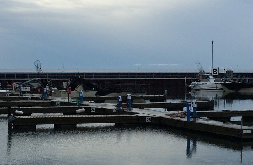Three boats are underwater and fire damage can be seen to two vessels docked in the Algoma Marina on Thursday.