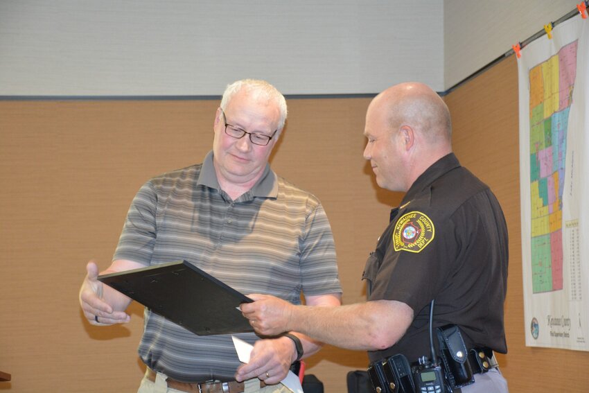 Chris Gulbrand of the Kewaunee County Sheriff's Department, left, is recognized on his retirement by Sheriff Matt Joski and County Chairman Bob Weidner for  his 30 years of service to the county.    "We appreciate everything he's done," said Joski, noting that Gulbrand would be continuing his service by volunteering to assist in  traffic and safety at Farm Technology Days 2017.