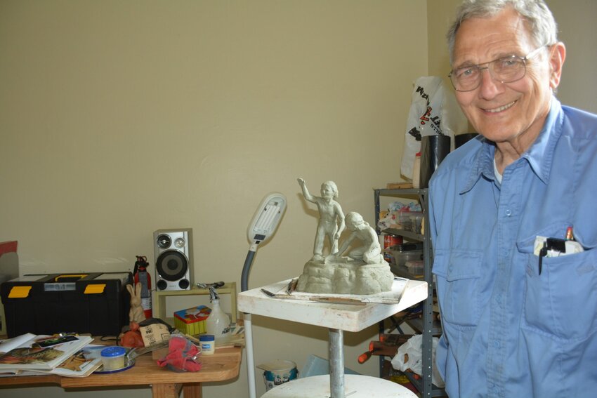 Dr. William Faller in his studio with a model of his proposed sculpture of two Native Americans boys.
