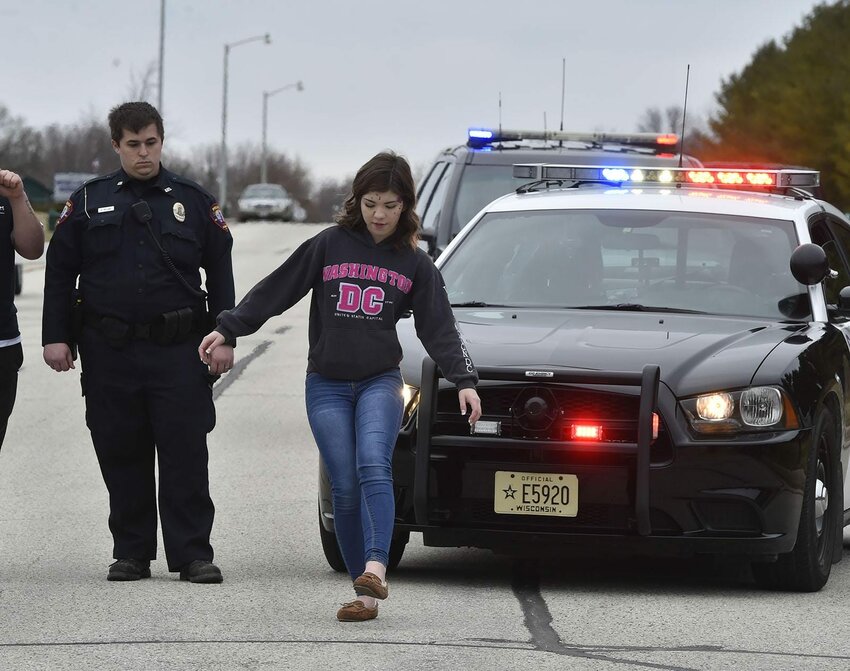 Cassidy Kohlbeck, playing the part of a driver in a two-car drunk driving accident, goes through a sobriety test during a re-enactment held Wednesday for Algoma High School students.