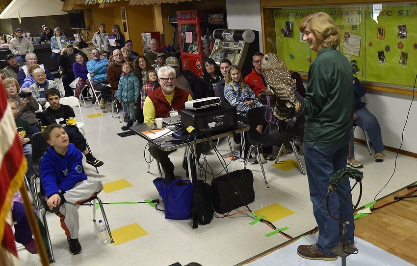 Kim Diedrich, chief naturalist of the Bay Beach Wildlife Sanctuary in Green Bay, shows celebration participants a barred owl as she tells them about the raptor’s characteristics and habitat. Diedrich also brought a live red-tailed hawk to the event.
