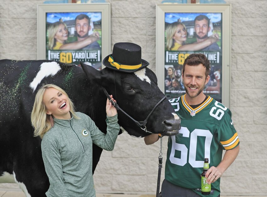 “The 60 Yard Line” actors Kim Crossman and Ryan Churchill pose for photos with Reaction, the Kewaunee County cow from the movie, before the Green Bay premiere Sept. 6 at Bay Park Cinema in Ashwaubenon.