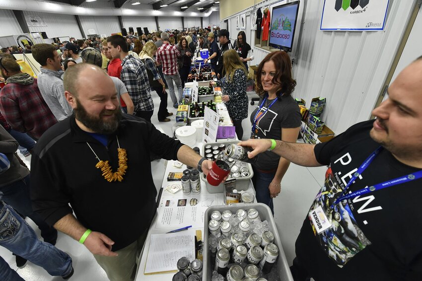 Corey Weinkoetz of Milwaukee-based craft brewery MobCraft Beer pours a sample of its Pivot Ale, a black ale, for Bill Gruhlke of Luxemburg at last year's Roar Off the Shore Brewfest,