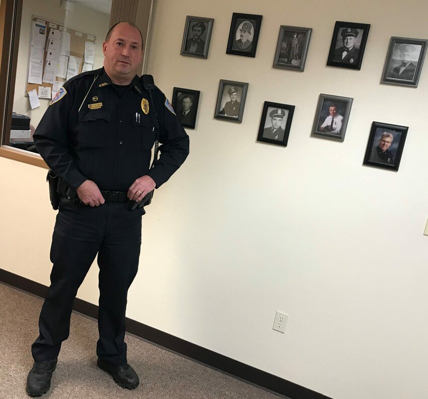 James Kleiman Jr. stands next to a wall of photographs of past chiefs of the Kewaunee Police Department. The 30-year member of the force joins their ranks as police chief Jan. 3.