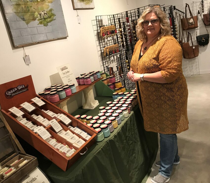 Kimberly Iwen of Algoma talks about the vendor artisans and their wares, including her own line of Queen Bee handmade soaps, candles and body care products, in her newly opened Honeycomb Holiday Pop-Up Shop in downtown Algoma. Also visible behind Iwen are leather goods, including holiday bells that can be hung from a door, by Peter Paul Jones of Waupaca.