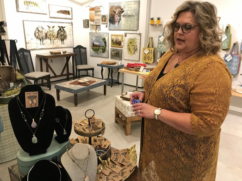 Kimberly Iwen of Algoma talks about the wire-strung stone and crystal jewelry by Terri Vlies of Crystal Nectar Creations in Algoma, one of about 10 vendors in her newly opened Honeycomb Holiday Pop-Up Shop in downtown Algoma. Iwen's own line of Queen Bee handmade soaps, candles and body care products is among the items available in the shop.