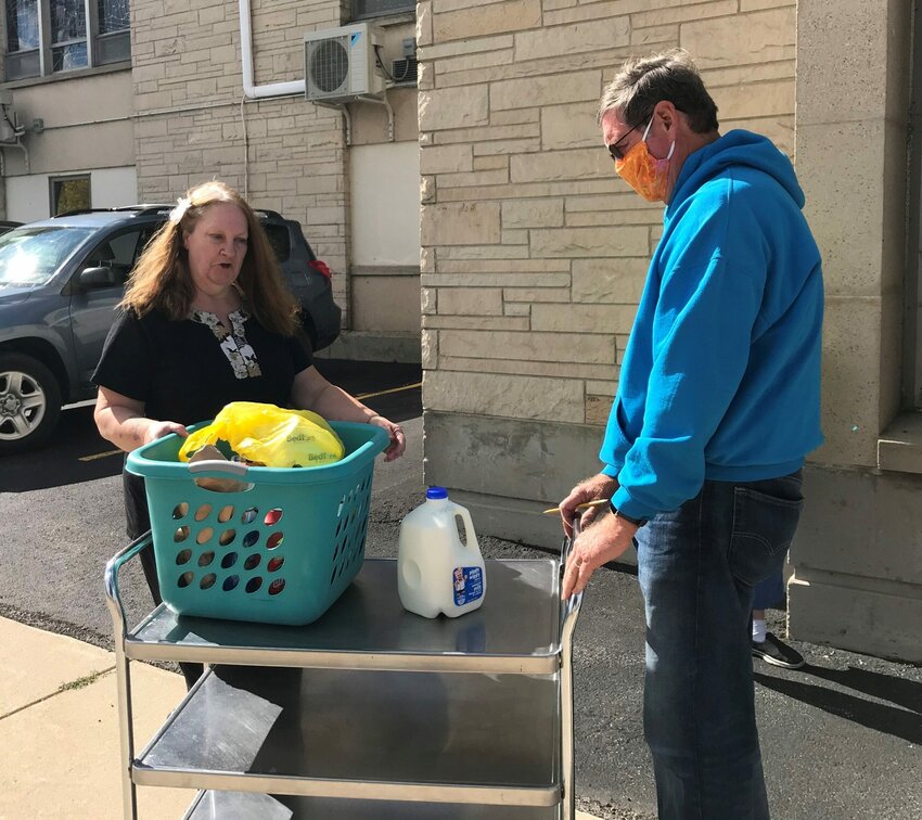 Susie Kezo of Algoma receives her food from volunteer/treasurer Dan Balch on Oct. 7 at the Lakeshore Community Pantry at Holy Rosary Church in Kewaunee.