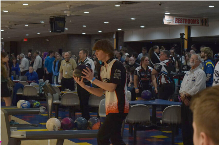 A male high schooler bowling