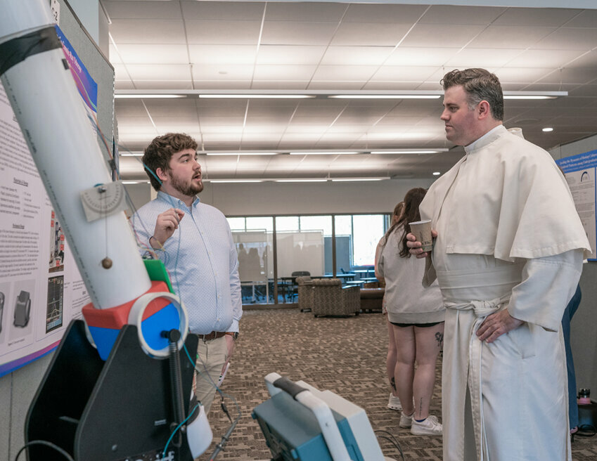 Benjamin Stafford explains his cosmic ray telescope to Father Mathew Dougherty