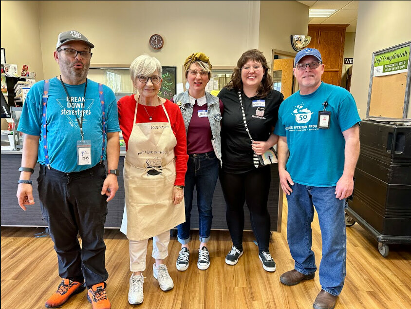 Through a collaboration with TimeSlips’ Tele-Stories and the Brown County Aging & Disability Resource Center (ADRC), 12 college students were partnered with elders to learn from one another and celebrate with an art presentation. Pictured are Aubrey Laux, second from right, and her collaborator “Jacki,” center, presenting their Tele-Stories partner “Nancy,” second from left, with an apron. Dr. Rebecca Meacham photo