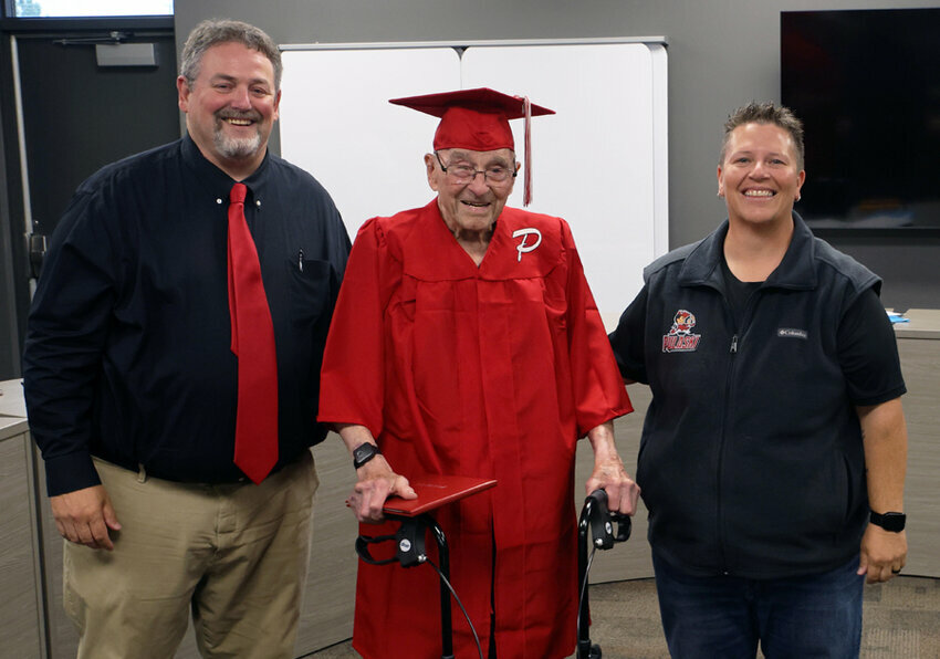 Jack Kraszewski received an honorary diploma from Pulaski High School Principal Matt Smith and Board of Education President Jennifer Schwarz. Pulaski Community School District photo