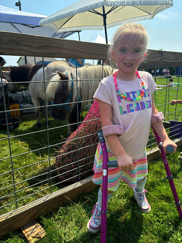 Kindergartener Molly Rozek pictured with horses in the background