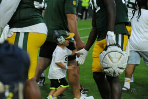 A child high fiving a Packers player