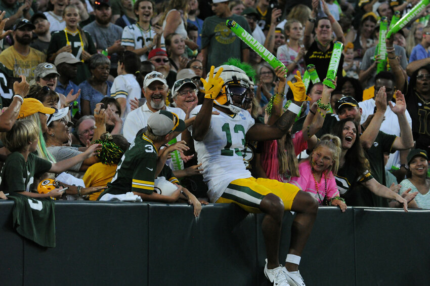 Green Bay Packers Wide Reciever Dontayvion Wicks performs the legendary Lambeau Leap after evading the defense and reaching the endzone in a drill on Family Night. Tori Wittenbrock photos