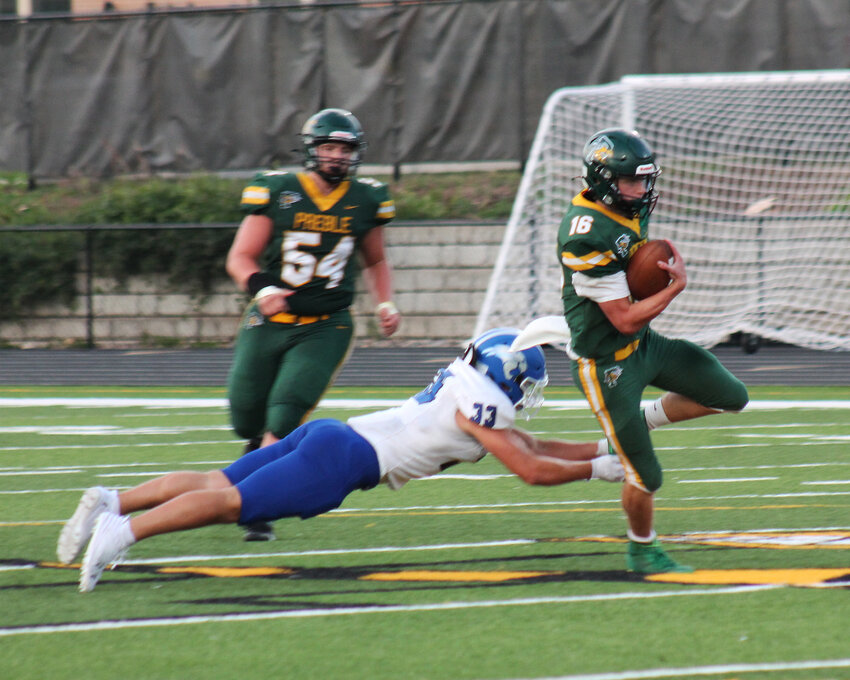 Preble Quarterback Gavin Sullivan tries to shake off Oshkosh Linebacker Zach Bartels during the Aug. 23 matchup on Preble High School newly installed turf.