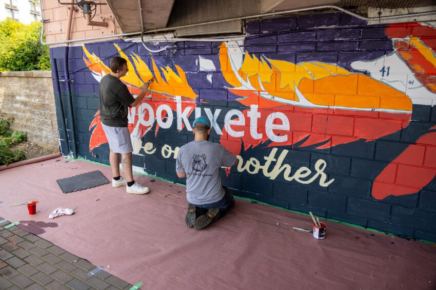 A vibrant 130-foot mural celebrating the Ho-Chunk Nation now fills a once-blank wall beneath the Dousman Street Bridge. The mural begins with the Ho-Chunk phrase “Wookixete,” meaning “love one another,