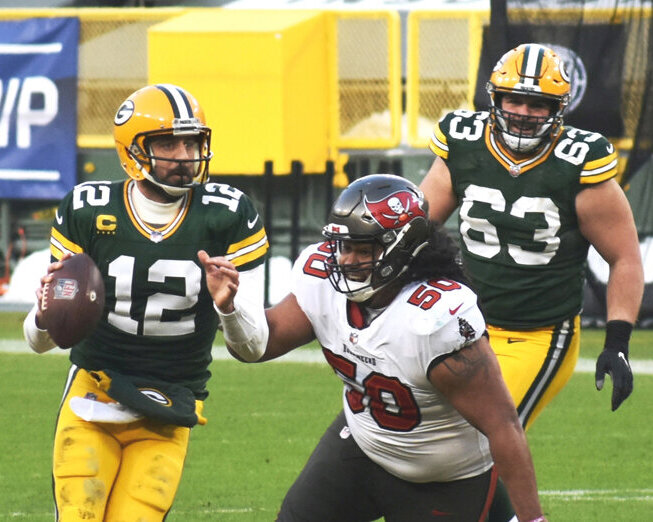 Green Bay Packers quarterback Aaron Rodgers prepares to throw a pass in the NFC Championship Game Jan. 24, 2021, with Tampa Bay nose tackle Vita Vea (50) giving chase.