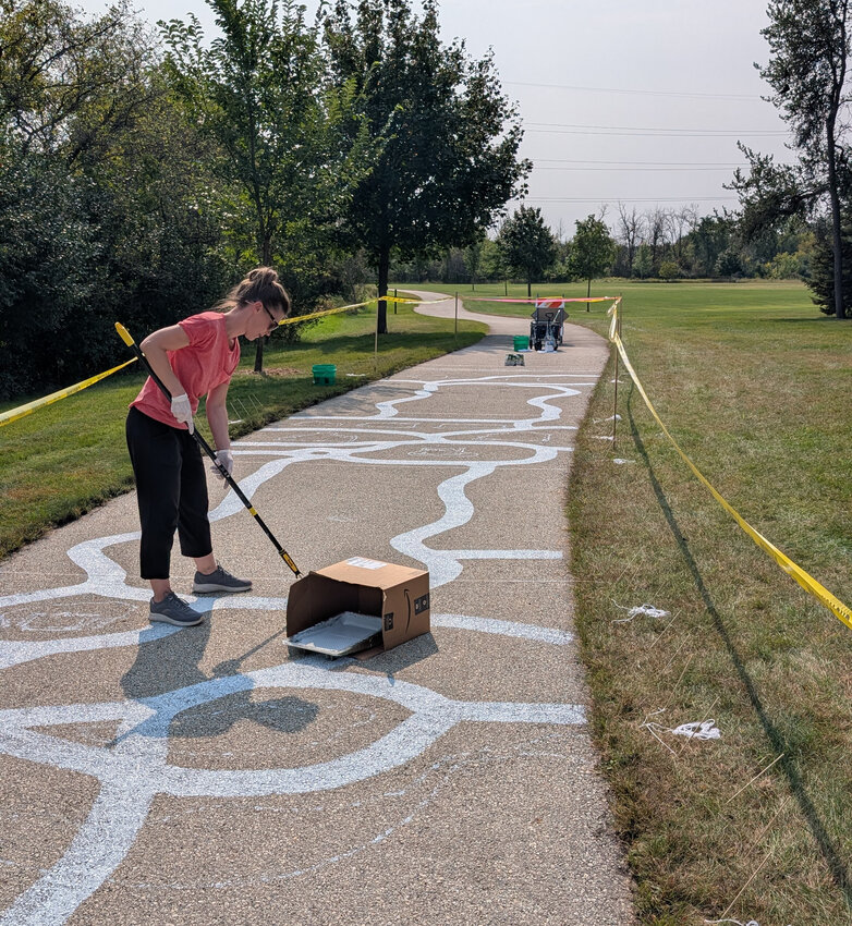 Local artist Carlie Petersen began work on her trail paintings in Ledgeview Park earlier this week.