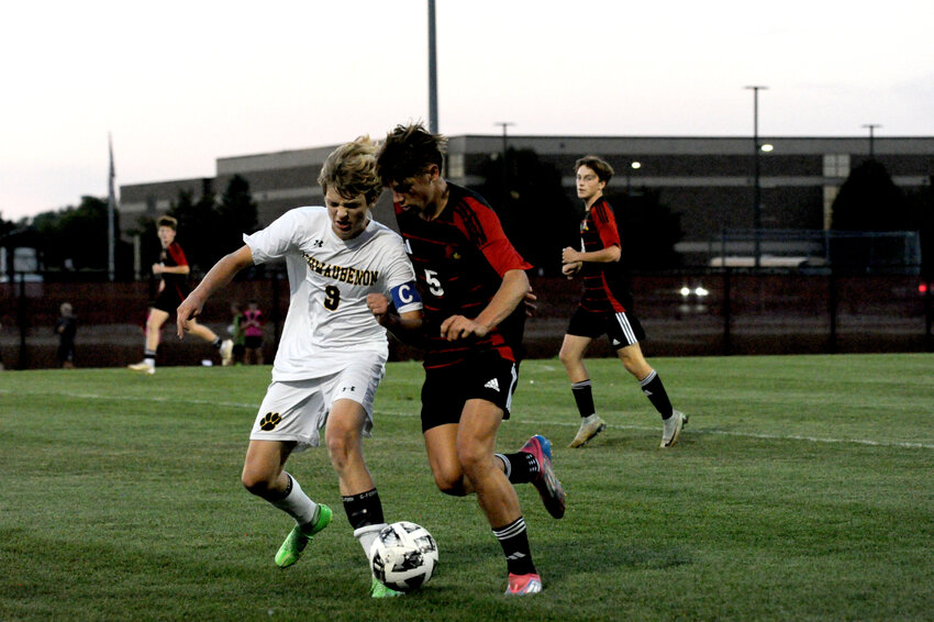 Ashwaubenon Captain Carter Nitke and De Pere's Brady Shanda engage in a battle at midfield during their Tuesday, Sept. 17, showdown. De Pere won the match up 8-1.