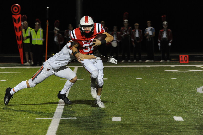 Pulaski’s Keaton Dauk makes a run up the field as he is tackled by West De Pere’s Adam Westberg.