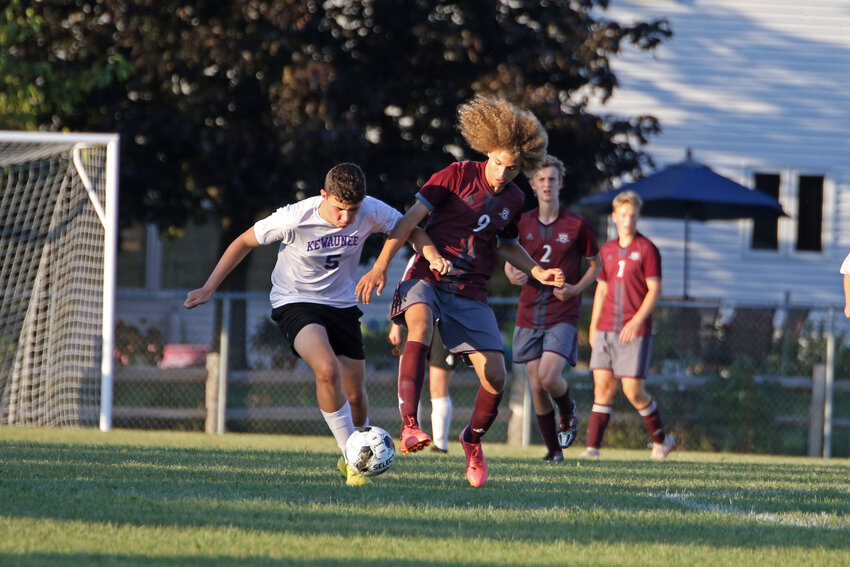 Kewaunee's #5 Henry Annen competes against NEW's #9 Lutheran Oscar Marty for possession of the ball.