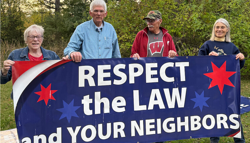 Shown holding one of the signs installed near U.S. Highway 10 ae :  Anita Olson, Bob Olson, Tom Wilson and Carol Falk..Photo courtesy of Mariko Fukuyama