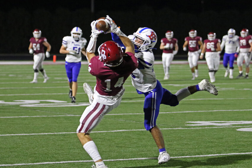 De Pere's Erick Brieno comes down with the reception despite close coverage from Appleton West's Charlie Blevins.