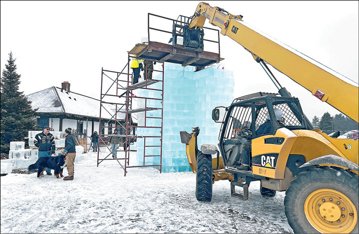 Former Eagle River Fire Department Fire Chief Pat Weber (right) and volunteers guided 13-inch blocks of crystal clear ice through a shaver to make them a uniform size prior to construction of the Eagle River Ice Castle near the railroad depot.