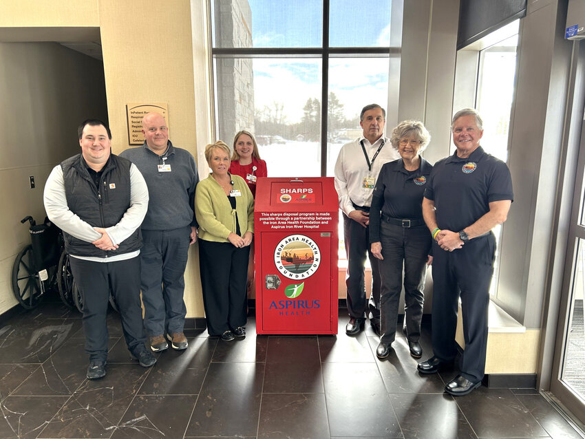 New Sharps Disposal Container. Pictured are, from left,  Zach Hautala (IAHF Board Member), Aaron Risbarg (Aspirus Iron River Facility Manager), Rae Kaare (Aspirus Iron River Hospital Administrator), Taylor Taylor (Aspirus Iron River Director of Nursing), Glenn Dobson (IAHF Board Member), Chris Kent (IAHF Board President) and Lyle Smithson Jr. (Director IAHF).