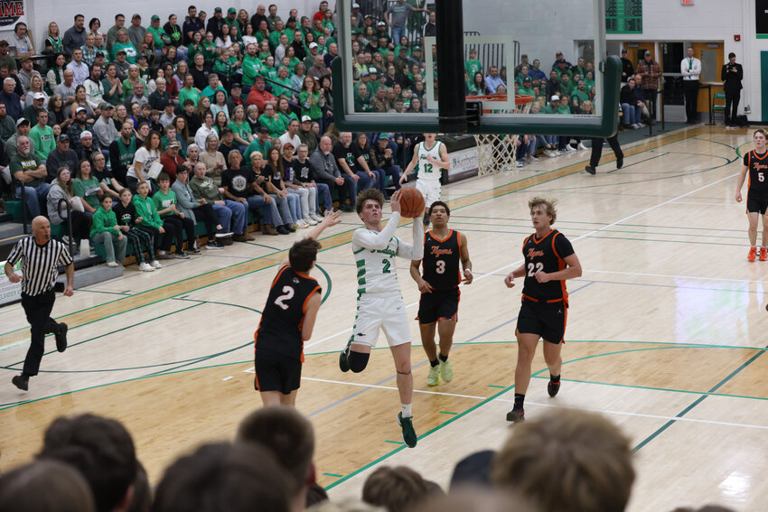 Devon Feck works his way around the New Richmond Tiger defenders to score 2 of his team leading 14 points.