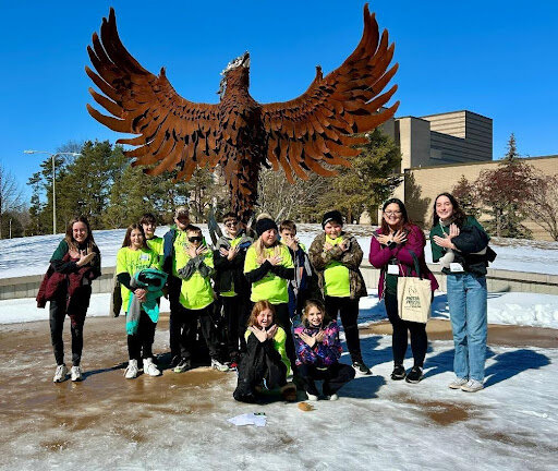 The fifth-graders posed in front of the Rising Phoenix statue with their tour guides.