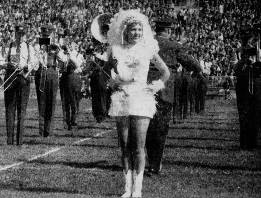 Van Duyse Sorgel serves as head majorette for the Packers Lumberjack Band in Ocotber 1957. Band Director Wilner Burke is directly behind her.