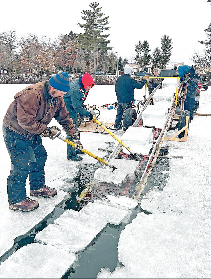 Eagle River Fire Department personnel and volunteers used hook poles to guide blocks of ice from Silver Lake to a conveyor and then to awaiting pickup trucks for the Eagle River Ice Castle.