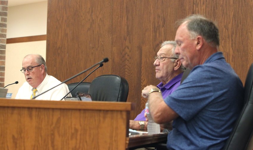 Moberly Mayor Jerry Jeffrey, left, and councilmen John Kimmons and Cole Davis, right, listen to a report shared while they participate in a city council business meeting held at City Hall.