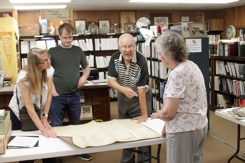 Missouri State Archives Local Records Division Archivist Mary Vogt McIntosh, left,  Thomas Stacy of Clark, a University of Missouri graduate student that has been volunteering his services at the Randolph County Historical Society, RCHS board member Joe Barnes and RCHS President Joyce Campbell, right, on June 16, 2021 take a look at what is believed to be the original City of Moberly map. The linen cloth document indicates it was officially filed as a township on Nov. 5, 1866. It was discovered by a Moberly man after he bought contents from a storage unit auction, and wishes to remain as an anonymous donor of this historical artifact to the RCHS.