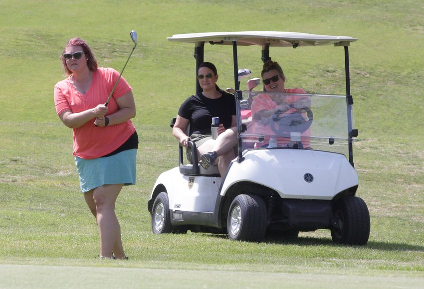 Angela Rash and Megan Jones sit in a golf cart as they watch Danielle Lindsey chip the golf ball onto the green at hole no. 2 as they participate in the Peak Sport &amp;amp; Spine Chipp-in For Kids Golf Tournament held June 8 at Heritage Hills Golf Course in Moberly. The event raised more than $4,200 that was divided among several school district's athletic depart,ents located within mid-Missouri.