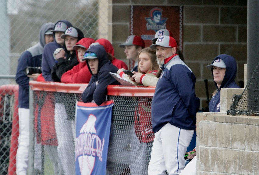 Moberly varsity head baseball coach Dale Heimann stands at the edge of the Spartans dugout as he and members of the team watch action taking place during a home game played earlier this 2021 season.