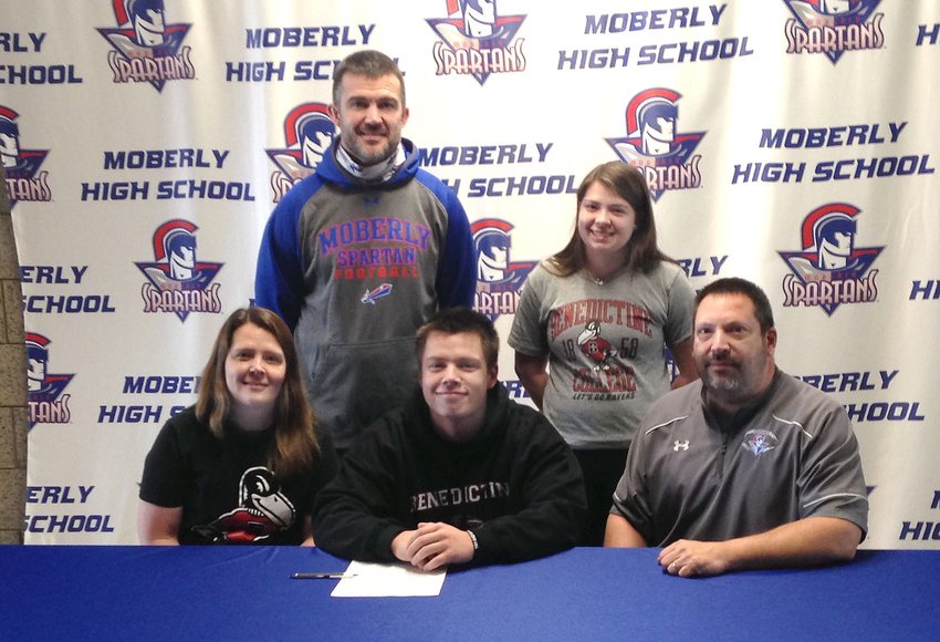 Moberly High School senior Dominic Stoneking sits between his parents, Tricia and Tony, during a letter of intent signing ceremony held Thursday, Jan. 28. Stoneking accepted a football scholarship offer fo the 2021-22 academic year at Benedictine College in Atchinson, Kan. Standing are Spartans head football coach Cody McDowell and Dominic's older sister, Isabella.