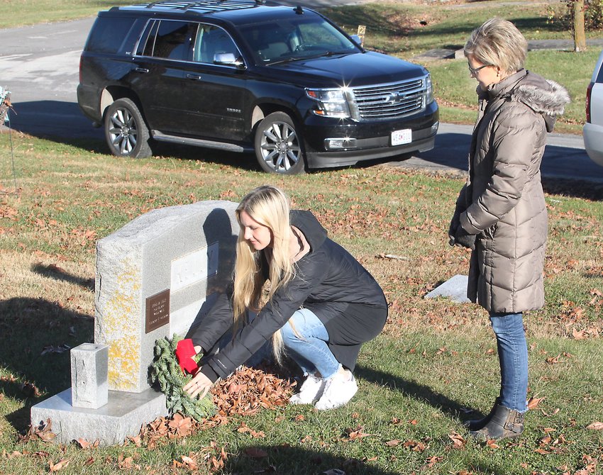 Mary McKeown stands and watches her niece, Lauren Kelly of Atlanta, Ga., place a decorative wreath Saturday morning at the Oakland Cemetery grave site of McKeown's father, U.S. Navy veteran Hugh M. Kelly, as they participate in the Moberly Altrusa Club's Wreaths of Honor event held Nov. 28.