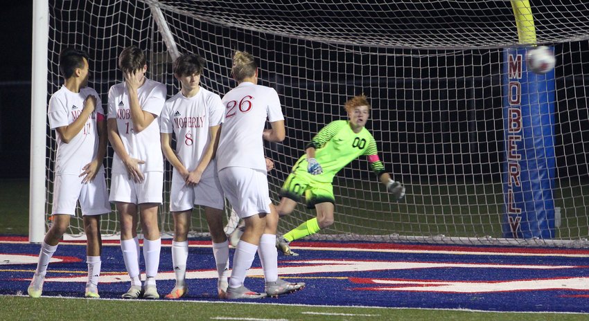 Spartans senior goalkeeper Andrew Imgarten moves to his left and gets some help when the ball from a Fulton free kick had just enough spin to barely miss its mark, striking the goal post and out of harm's way Thursday during the first half of the Class 2 District 6 soccer championship game played at Moberly. Spartan defenders Isaiah Lopez (left), Landon Stone, Jordan Rasico (#8) and Patrick Wilborn (#26) formed the wall to help defend the free kick. Fulton defeated Moberly 3-2.