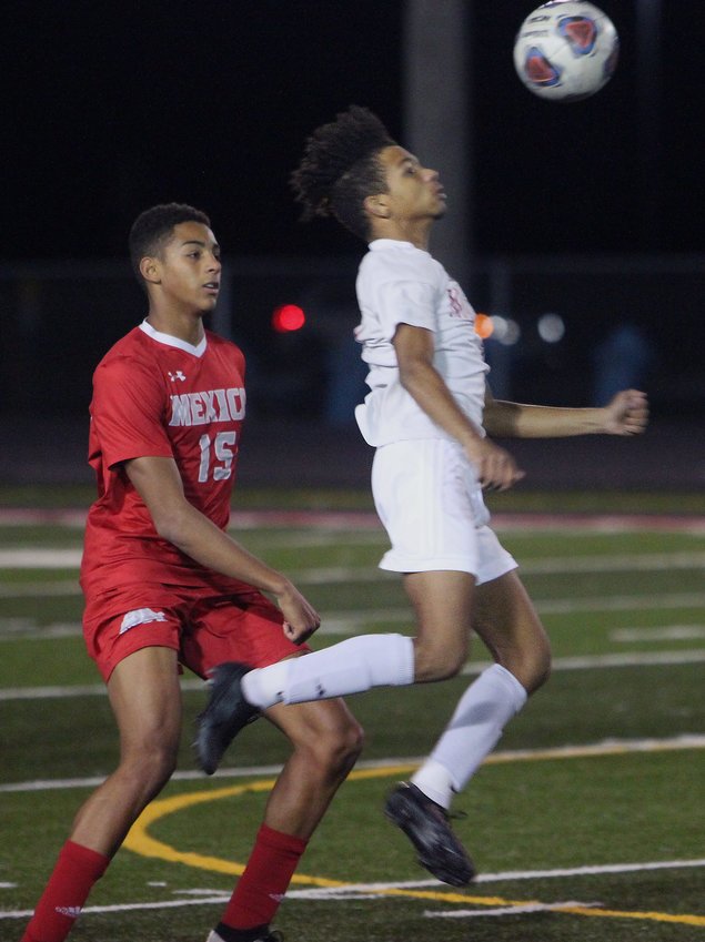 Moberly junior forward Charez Nichols leaps to settle a 50/50 ball using his chest Tuesday while being defended by Mexico's Daeye Miller (No. 15) Tuesday during a Class 2 District 6 semifinal. The Spartans won 2-1 in double overtime to advance and play Fulton in Thursday's championship game.