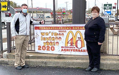 McDonald's of Moberly General Manager Susan Foster, right,  was recognized for her 40 years of service Tuesday during a surprise celebration held in her honor. Chuck Marshall, owner/operator of McDonald's of Moberly, is shown with Foster next to a banner erected at the restaurant.