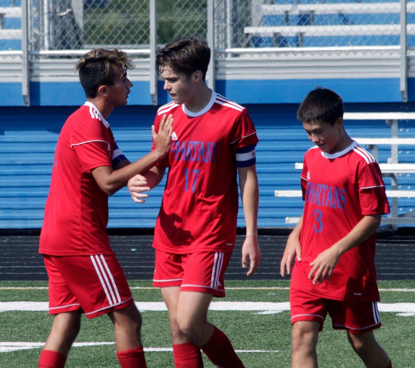 Moberly senior Isaiah Lopez reaches to tap the chest of Will O'Loughlin to congratulate the Spartans forward after O'Loughlin  scored his fourth of six goals Saturday morning en route to Moberly celebrating a  7-3 win against Mexico at the Spartans Soccer Invitational. Also shown is freshman (#3) Ryan O'Loughlin.