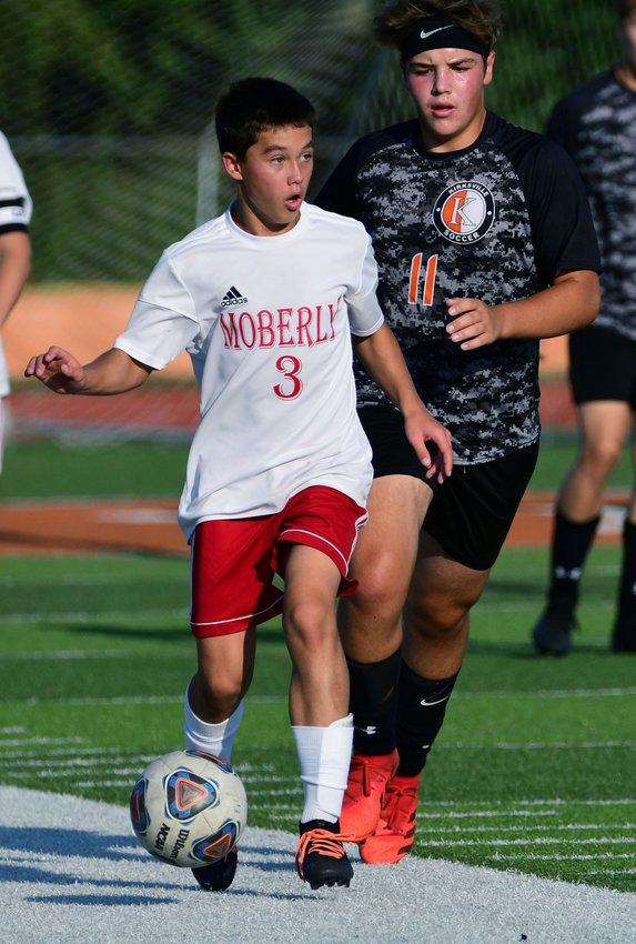 Moberly High School freshman Ryan O'Loughlin looks to distribute the soccer ball as he pushes it upfield Thursday during the Spartans 5-1 victory at North Central Missouri Conference rival Kirksville.