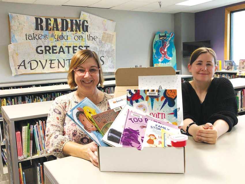 Melissa Wetzel and Robin Fara, Little Dixie Regional Libraries staff, share the new youth book box service with patrons at the local library.