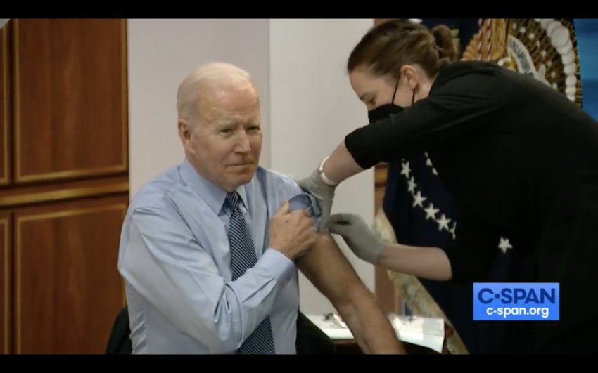 President Joe Biden rolls up his sleeve to get his second booster shot from a member of the White House medical unit.