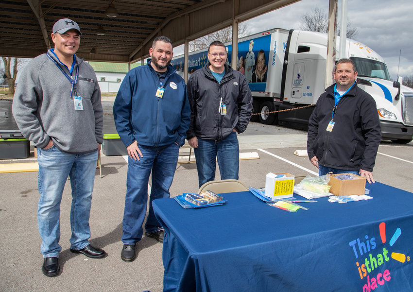 Representatives of Walmart&rsquo;s distribution center in Moberly wait for job seekers Wednesday in Rothwell Park. From left are Tony Contreras, Dan Martinez, Seth Taylor and Bronson Kribbs.