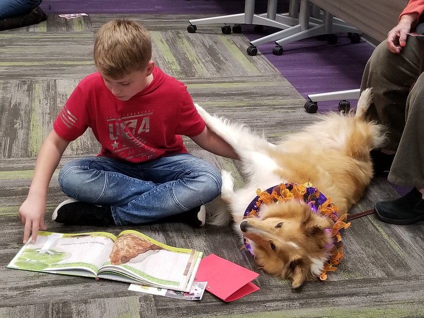 A child reads to a therapy dog during a Reading to Rover program at the Moberly library in October 2019.
