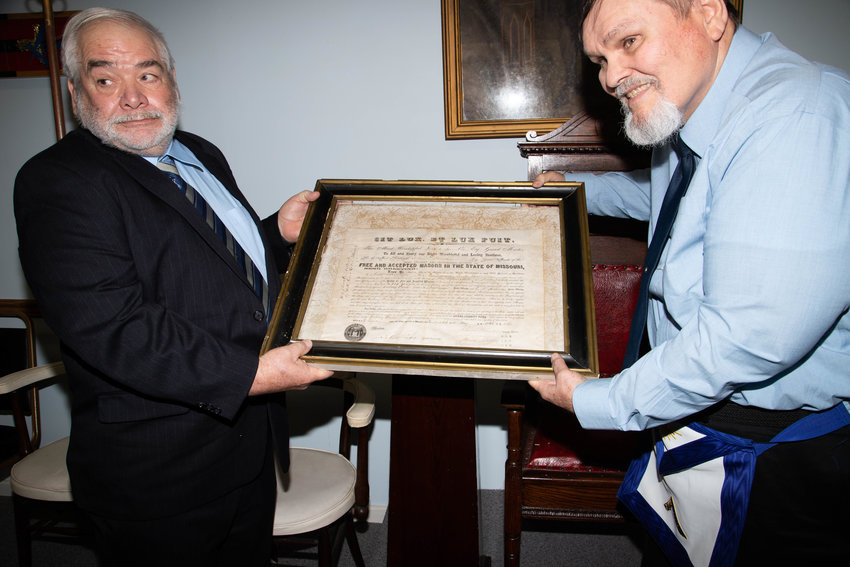Milton Masons Bob Hutchinson and James Rockenfield hold the original charter of Milton Lodge 151 during a retirement ceremony in Cairo Saturday. The Milton Lodge merged with the Cairo Lodge because of falling attendance.