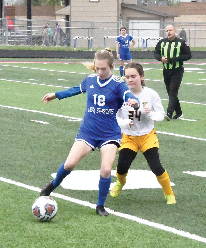 Moberly defender/midfielder Chloe O&rsquo;Donnell (18) makes a play on the ball while pursued by a Fulton player during last Thursday&rsquo;s girls&rsquo; soccer game at Dr. Larry K. Noel Spartan Stadium. The Spartans tripped up the Hornets, 1-0, in this North Central Missouri Conference match.